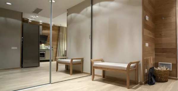 Lemari dengan cermin besar sebagai pintu, menciptakan ilusi ruangan yang lebih luas